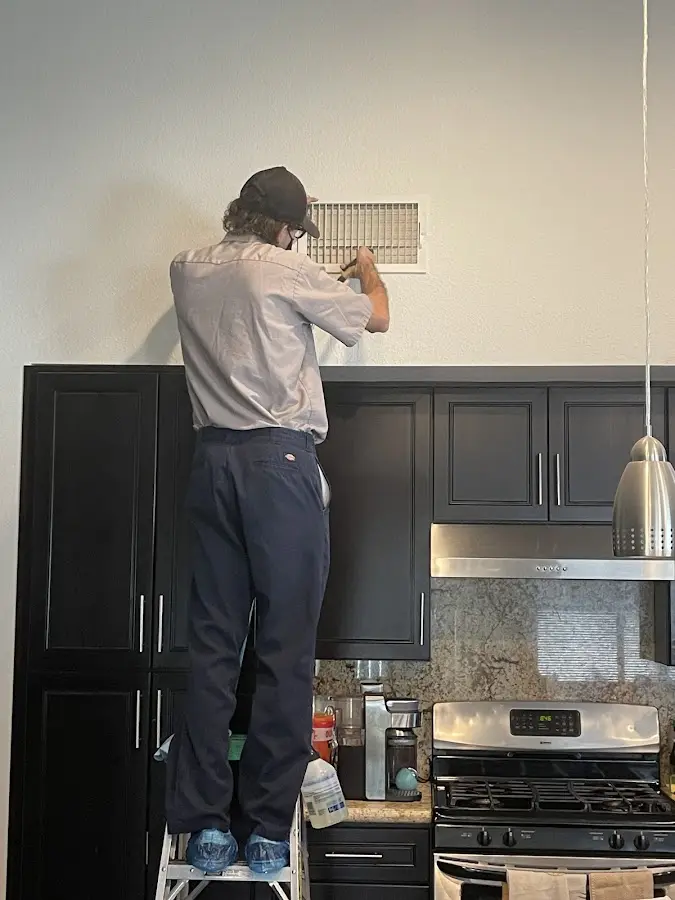 Technician inspecting an air vent during HVAC service in Dyersburg